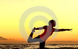 Active woman in sport clothes on seacoast stretching