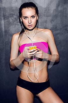 Active Woman standing with Headphones in Indoor Studio