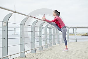 Active Woman Stretching on Pier