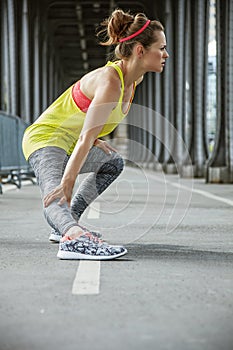 Active woman stretching on Pont de Bir-Hakeim bridge in Paris