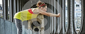 Active woman stretching on Pont de Bir-Hakeim bridge in Paris