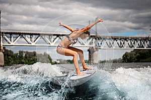 Active woman on surfboard energetically rides the wave