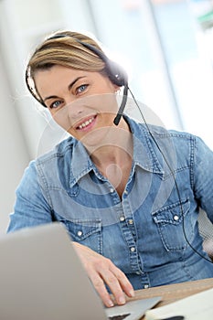 Active woman teleworking from home with headphones