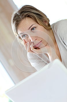 Active woman teleworking on laptop getting bored photo