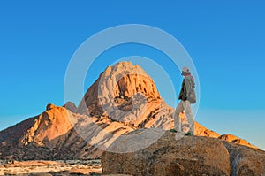 Active woman tourist travels in Spitzkoppe nature reserve, Damaraland, Namibia