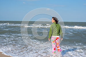 Active woman walking in the surf line