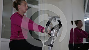 Active women in sport shoes pedaling on a stationary bike in the gym