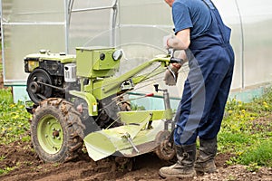 Active Worker Elderly Man With Tractor On Agricultural Field In Spring Close