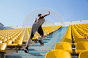 Active young african sportsman climbing up the stairs