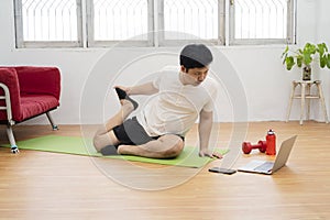 Active young cheerful man doing morning gymnastic at home