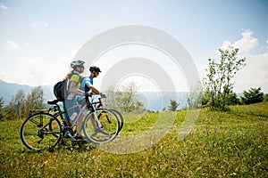 ACTIVE Young couple biking on a forest road in mountain on a spring day