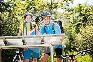 ACTIVE Young couple biking on a forest road in mountain on a spring day