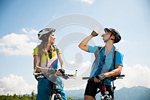 ACTIVE Young couple biking on a forest road in mountain on a spring day