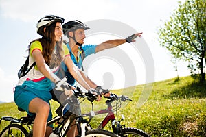 ACTIVE Young couple biking on a forest road in mountain on a spring day