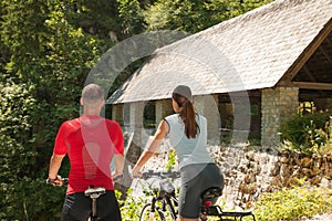 Active young couple cycling in forest on a hot summer day