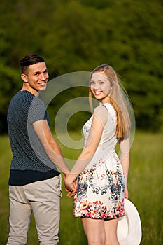 Active young couple on a wlak in the park on hot summer afternoon