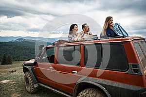 Active young friends using travel map in the mountains