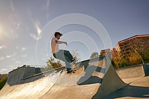 Active young man doing tricks on his skateboard at the skate park. Active sport concept