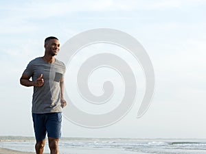 Active young man jogging at the beach