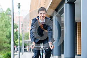 Active young man smiling while riding utility bicycle to his wor