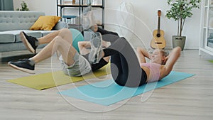 Active young people husband and wife training at home doing sports together on yoga mats