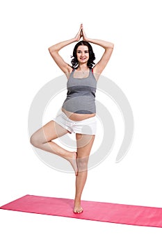 Active young pregnant woman doing yoga