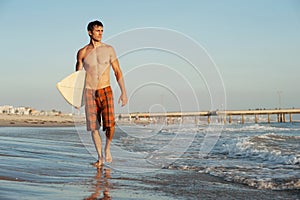 Active young surfer holding a surfboard