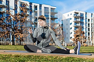 Active young woman checking her mobile phone during outdoor work