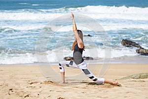 Active young woman doing sports excercises on the beach