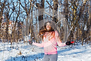 Active young woman performs an exercise with a skipping rope