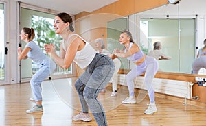 Active young woman practicing aerobic dance in training hall
