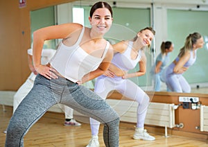 Active young woman practicing aerobic dance in training hall