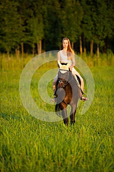 Active young woman ride a horse in nature