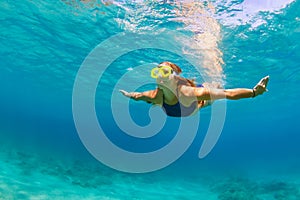 Active young woman in snorkeling mask dive, swim underwater