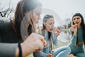 Active young women enjoying healthy snacks at the park after workout