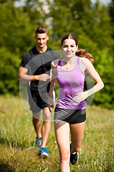 Active young youple running cross country in nature on a fores