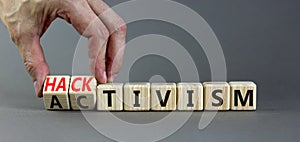 Activism or hacktivism symbol. Businessman turns wooden cubes and changes the word Activism to Hacktivism. Beautiful grey table photo