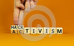 Activism or hacktivism symbol. Businessman turns wooden cubes and changes the word Activism to Hacktivism. Beautiful orange table photo