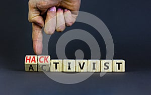 Activist or hacktivist symbol. Businessman turns wooden cubes and changes the word Activist to Hacktivist. Beautiful grey table