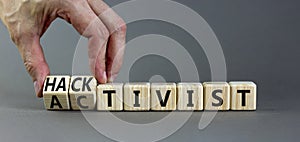 Activist or hacktivist symbol. Businessman turns wooden cubes and changes the word Activist to Hacktivist. Beautiful grey table