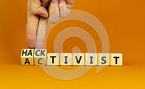 Activist or hacktivist symbol. Businessman turns wooden cubes and changes the word Activist to Hacktivist. Beautiful orange table