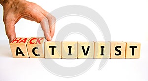 Activist or hacktivist symbol. Businessman turns wooden cubes and changes the word Activist to Hacktivist. Beautiful white table
