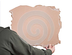 Activist hand holding a blank cardboard sheet, participating in a street demonstration or protest. Blank banner for advertising