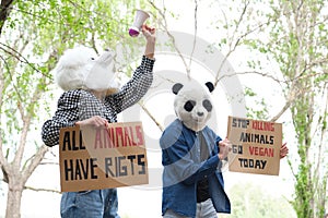 Activist protesters wearing animal masks shouting through a bullhorn.