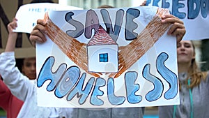 Activists with Save homeless poster chanting to support migrants, refugee rights