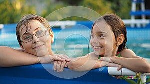 Activities on the pool. Cute kids - sister and brother swimming and playing in water in swimming pool in aquapark