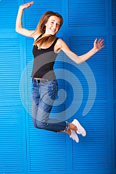 Activity and happiness concept - smiling teenage girl in white blank t-shirt jumping