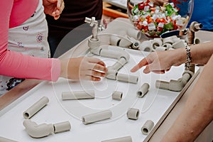 Activity for kids indoor, play and creativity concept. Kids are playing with fun tunnels and pipes set, plastic block kit. Fun-