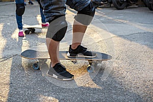 Activity leisure skate lifestyle concept. Legs of athletic man playing surf skate on the road with sunlight in the evening for