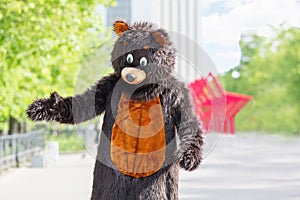 actor dressed as bear walks avenue of park on photo